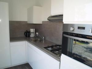 a kitchen with white cabinets and a stove top oven at Charming Chalet in De Rijp in West-Graftdijk