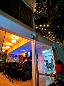 a bar with stools in a restaurant with purple lights at Napoli Centro in Santa Ana