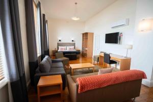 a living room with a couch and chairs and a bed at Park Hotel in Mount Gambier