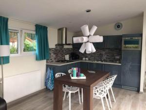 a kitchen with a dining table and a ceiling fan at Charming Chalet in De Rijp in West-Graftdijk