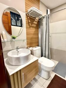 a bathroom with a sink and a toilet and a mirror at Lafontana Hometel in Roxas City +41 photos