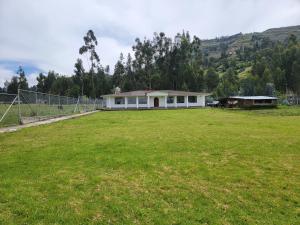 a house in a field with a large yard at Hospedaje Campestre María Eugenia in Cajamarca