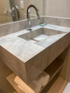 a kitchen sink with a concrete counter top at Areiao Park Hotel in Goiânia