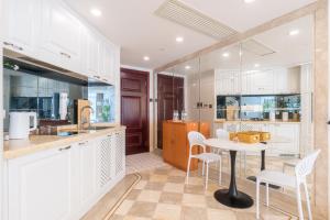 a kitchen with white cabinets and a table and chairs at Shanghai Little 8 Apartment in Shanghai
