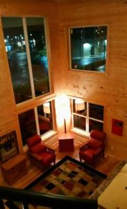 a living room with red chairs and a table and windows at Rolling Hills Lodge in Cherokee +2 photos