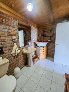a bathroom with a sink and a brick wall at Casa Amanecer Vichuquén in Vichuquén Lake