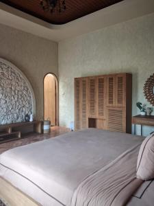 a bedroom with a large bed and wooden cabinets at Princessa Villa by Raminten in Pakem