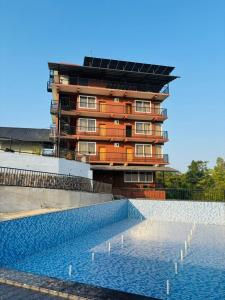 a building with a swimming pool in front of a building at Hill View Resort - Kannur in Pālayangadi