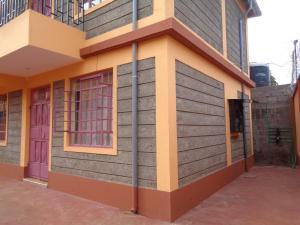 a side view of a house with purple doors at Snug Spot BnB-Mwea in Thiba