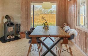 a dining room with a wooden table and a fireplace at 2 Bedroom Amazing Home In Slagelse in Slagelse