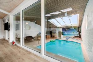 a swimming pool in a house with a large window at 8017-Knebel-Manhojvej-1 in Knebel