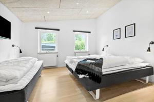 two beds in a room with white walls at 8017-Knebel-Manhojvej-1 in Knebel +26 photos