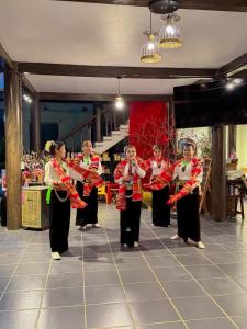 a group of women standing on a stage playing music at Trám House in Cao Phong