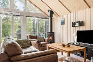 a living room with a couch and a tv and a table at 84148-Ebeltoft-Sivsangervej-47 in Ebeltoft