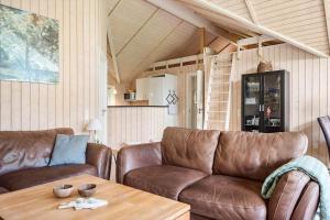 a living room with two brown leather couches and a table at 84148-Ebeltoft-Sivsangervej-47 in Ebeltoft