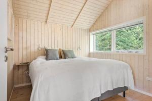 a bedroom with a large white bed with a window at 84148-Ebeltoft-Sivsangervej-47 in Ebeltoft