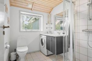 a bathroom with a toilet and a sink and a washing machine at 84148-Ebeltoft-Sivsangervej-47 in Ebeltoft +18 photos