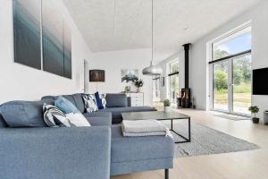 a living room with a blue couch and a table at 84160-Ebeltoft-Baekholmen-5-A in Ebeltoft