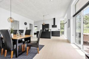 a dining room with a table and black chairs at 84160-Ebeltoft-Baekholmen-5-A in Ebeltoft