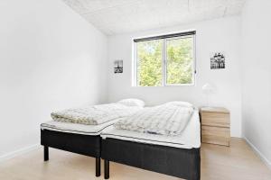 a bed in a white room with a window at 84160-Ebeltoft-Baekholmen-5-A in Ebeltoft