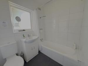 a white bathroom with a sink and a tub and a toilet at Tamar Vista Retreat in Legana