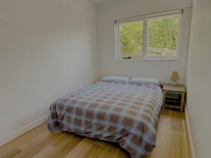a bed in a white room with a window at Tamar Vista Retreat in Legana