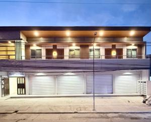 a large building with white doors and a balcony at Lafontana Hometel in Roxas City