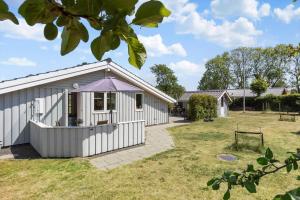 a white shed with a purple roof in a yard at 8014-Knebel-Rastestedet-16 in Knebel