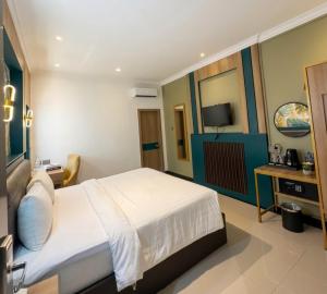 a hotel room with a bed and a television at Bona Ventura Hotel & Skybar in Tanjung Pinang