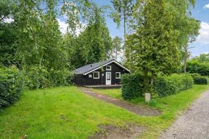 a black cabin in the middle of a yard at 8116-Ega-Under-Ronnene-37 in Egå +16 photos