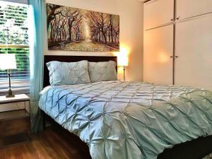 a bedroom with a bed with a painting on the wall at Large Fenced Yard, Pool Table, Disney Central in Fullerton