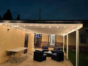 a pergola with lights on a patio at night at Large Fenced Yard, Pool Table, Disney Central in Fullerton
