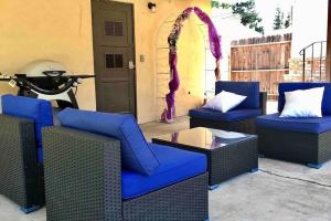 a patio with blue chairs and a table and a motorcycle at Large Fenced Yard, Pool Table, Disney Central in Fullerton