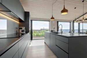 a kitchen with gray cabinets and a large window at 84213-Ebeltoft-Lokevej-8 in Ebeltoft +12 photos