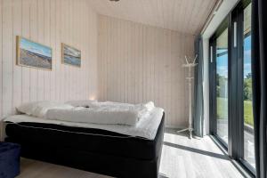 a bedroom with a bed and a large window at 84213-Ebeltoft-Lokevej-8 in Ebeltoft