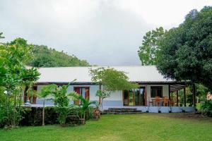 a small white house with a yard at Eco-Villa Camiguin in Mambajao
