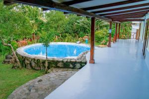 a swimming pool in a yard with a patio at Eco-Villa Camiguin in Mambajao