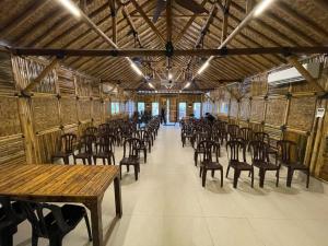 a room with rows of chairs and wooden tables at Tadom Hill Resorts in Kampong Labohan Dagang