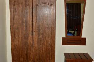 a wooden cabinet in a room with a mirror at Vybhav Residency AC in Anantapur +1 photo