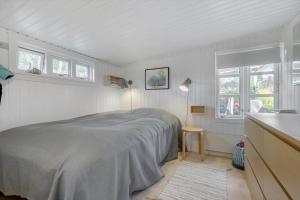 a white bedroom with a bed and a window at 8224-Knebel-Capellavej-7 in Knebel