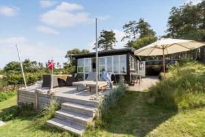a person sitting on a porch of a tiny house at 8224-Knebel-Capellavej-7 in Knebel
