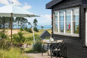 a table and an umbrella outside of a house at 8224-Knebel-Capellavej-7 in Knebel +16 photos