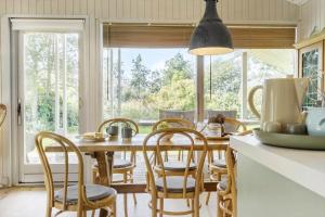 a kitchen with a wooden table and chairs and a large window at 8211-Knebel-Basbjergvej-5 in Knebel