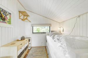 a bedroom with two beds and a desk and a window at 8211-Knebel-Basbjergvej-5 in Knebel