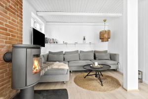 a living room with a couch and a fireplace at 8113-Ronde-Strandvejen-91 in Rønde
