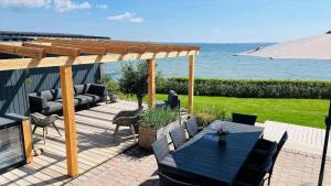 a patio with a table and chairs and the ocean at 8113-Ronde-Strandvejen-91 in Rønde