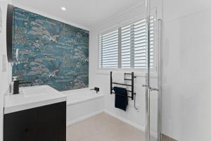 a bathroom with a tub and a sink and a window at Roslyn Sanctuary Hereford St Dunedin in Dunedin +22 photos