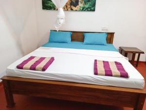 a bed in a room with two pillows on it at Vintage rooms in Dickwella