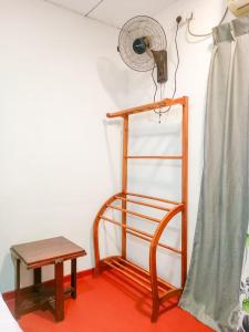 a room with a chair and a fan and a table at Vintage rooms in Dickwella