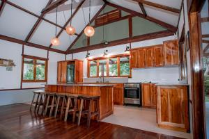 a kitchen with wooden cabinets and bar stools at Eco-Villa Camiguin in Mambajao